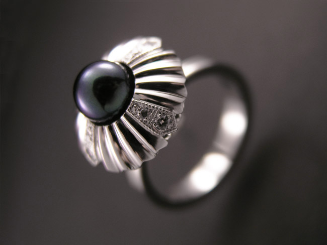 prstan iz belega zlata s črno perlo in cirkoni